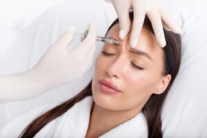 Woman receiving Botox® injections from a skilled professional, targeting fine lines and wrinkles for a smoother, more youthful appearance.